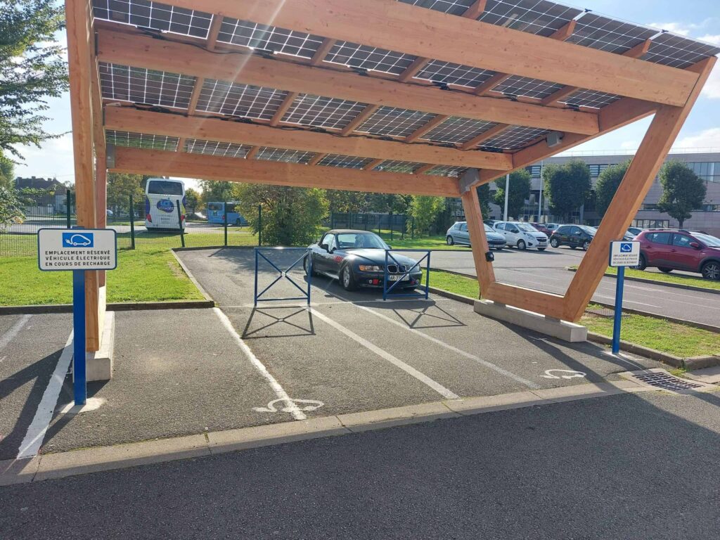 Pensilina fotovoltaica in pieno sole che copre due posti auto con punto di ricarica.