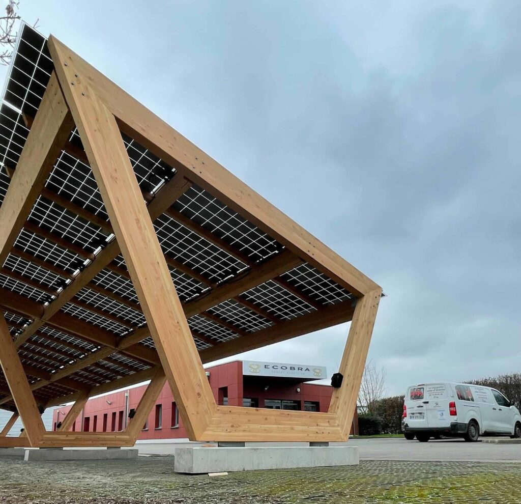 Tettoia fotovoltaica con struttura in legno e camion sulla destra.