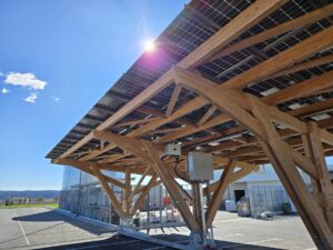 Una pensilina fotovoltaica in legno sotto il sole.