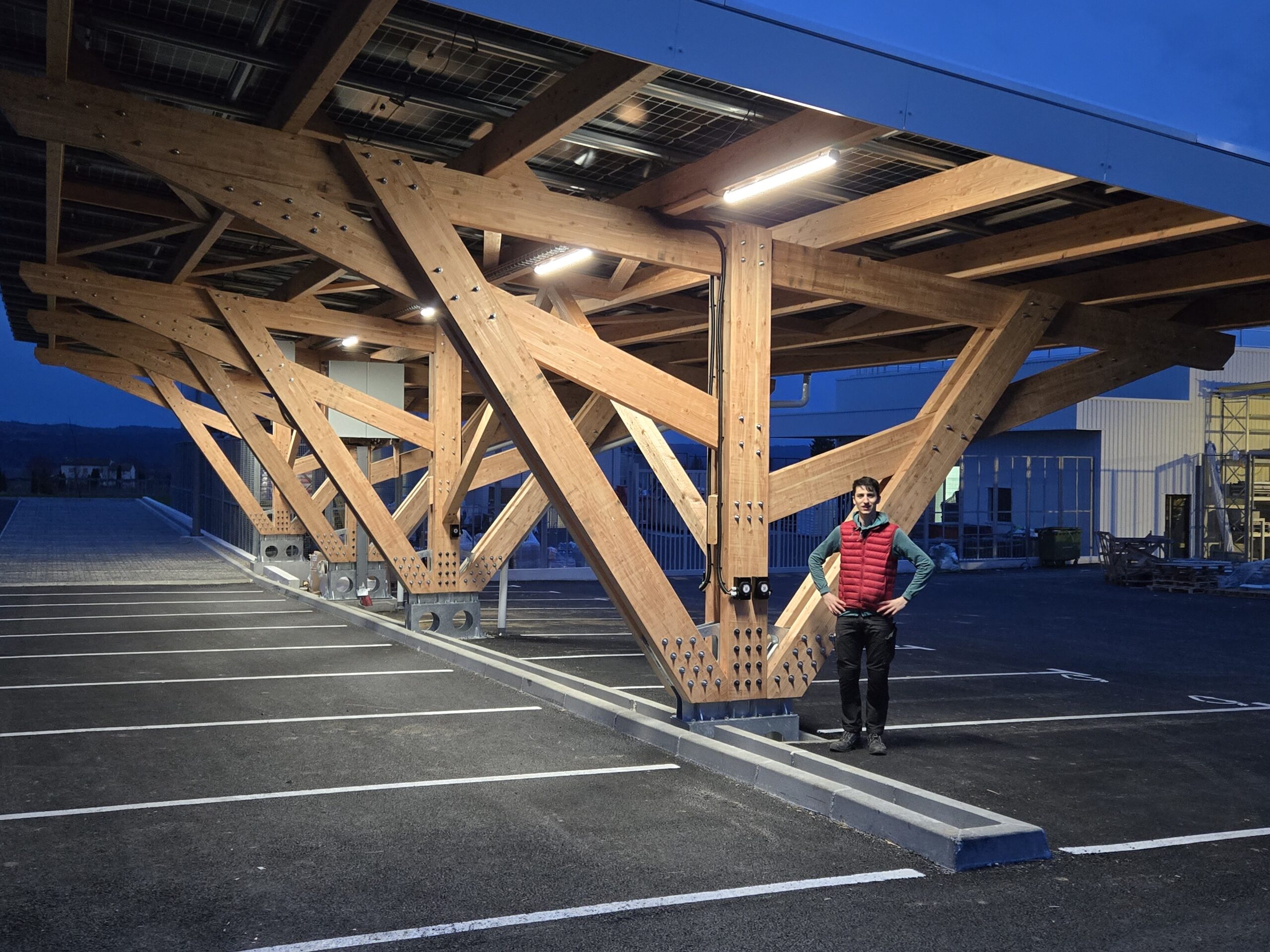 Tettoia fotovoltaica in legno illuminata di notte