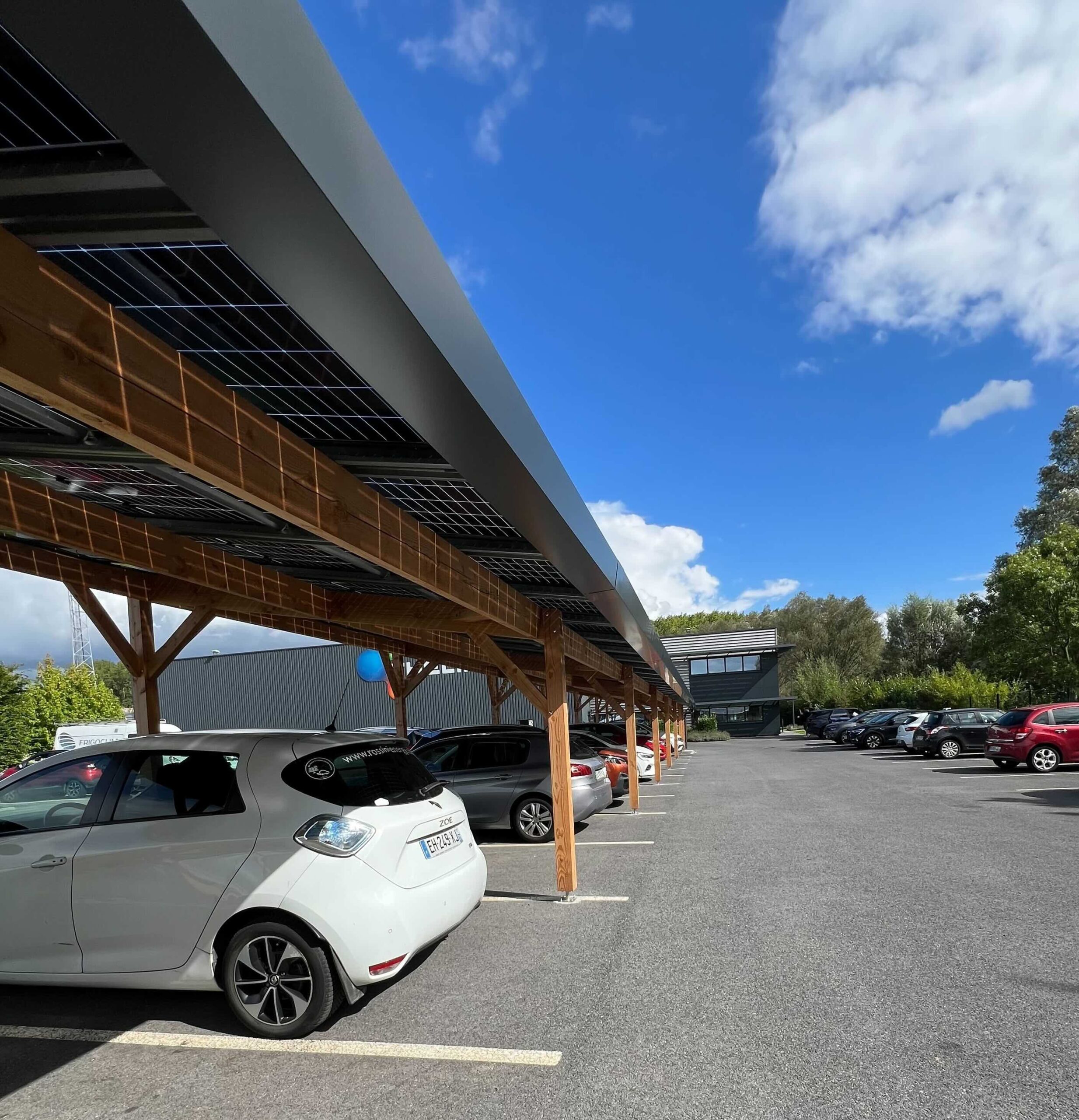 Tettoia fotovoltaica in legno con auto parcheggiate